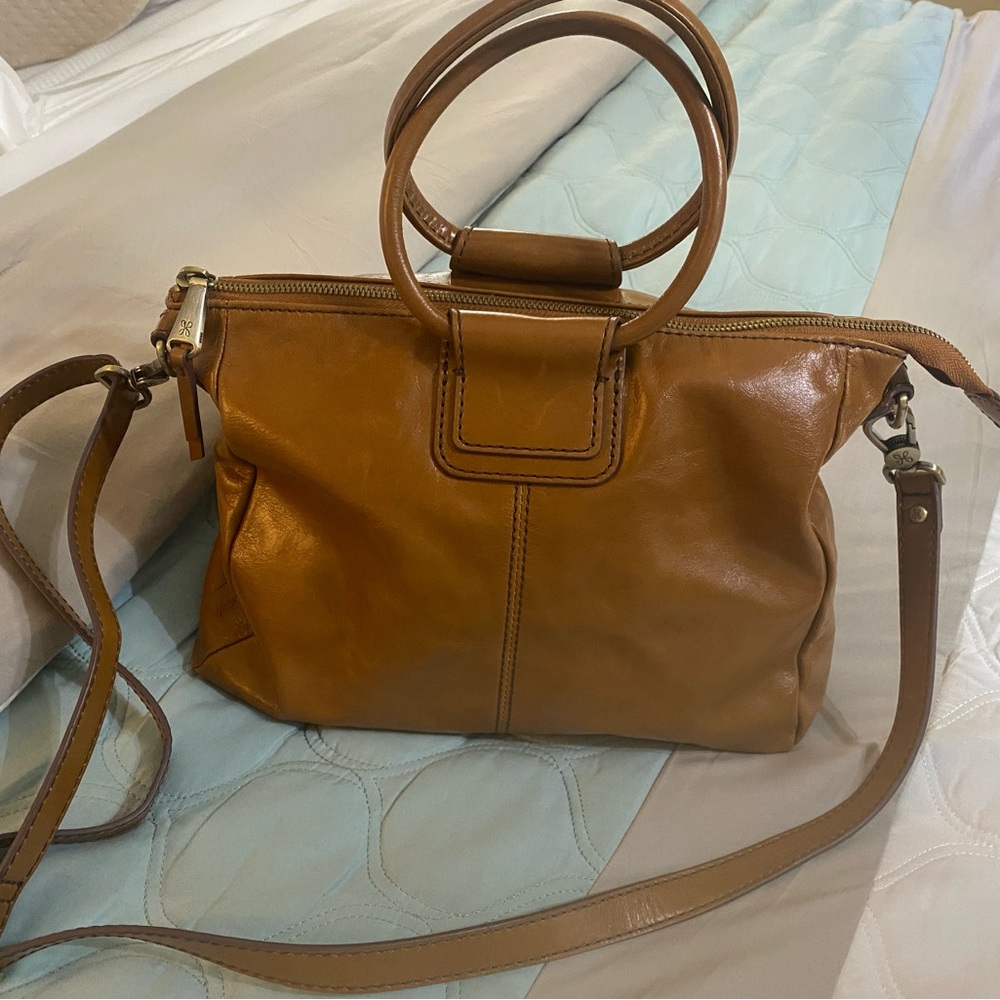 A medium satchel with a top handle and an adjustable removable strap.